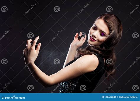 Attractive Young Brunette Woman And A Bottle With A New Fragrance Use