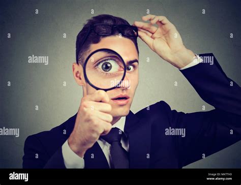 Curious Man Taking Off Glasses Looking Through A Magnifying Glass Stock