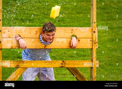 Youngster Gets A Wet Sponge Thrown At Him In The Stocks At A Village