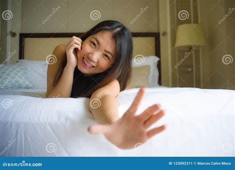 Young Beautiful And Happy Asian Chinese Woman Lying On Bed In The