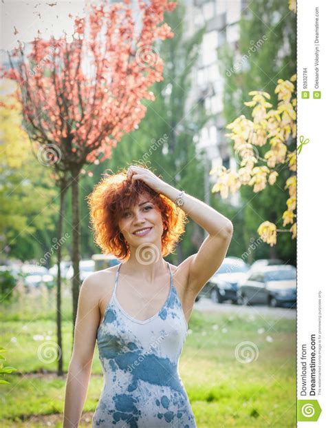 photo of a beautiful redhead woman or girl in the park