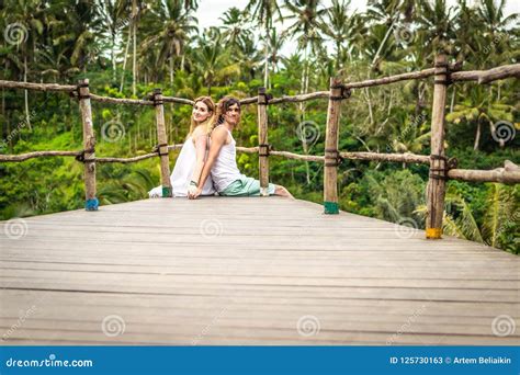 Young Honeymoon Couple Posing On The Bridge Deep In The Jungle