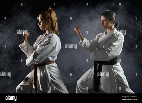 Female Karatekas Training In White Kimono Combat Stance In Action
