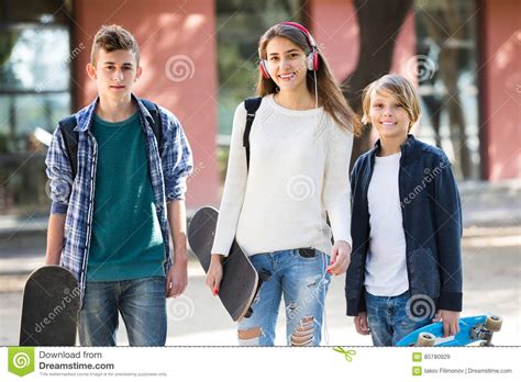 three teenagers with skateboards outdoor stock image