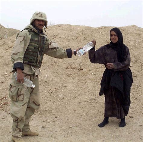 Coalition Soldier Gives Water To Iraqi Woman