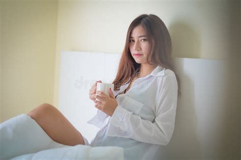 Beautiful Brunette Woman Drinking And Morning Coffee In Bedroom Stock
