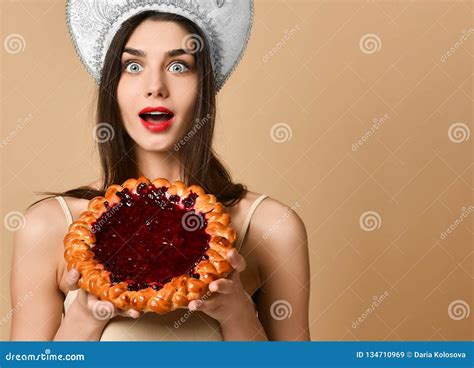 shocked beauty russian woman in kokoshnik hat has cake during dinner