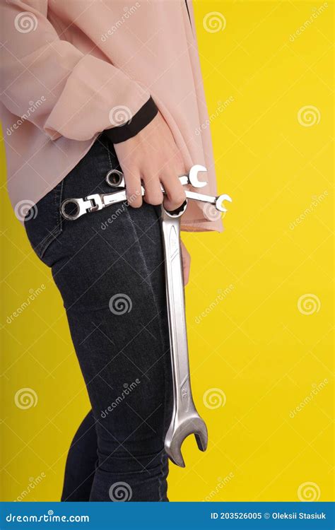 Girl Holding Wrenches In Her Hands On A Yellow Background Stock Image