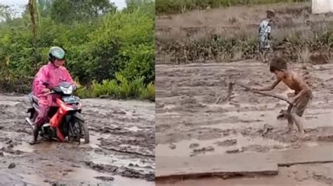jalanan rusak  penuh lumpur anak anak sd bantu pemotor melintas