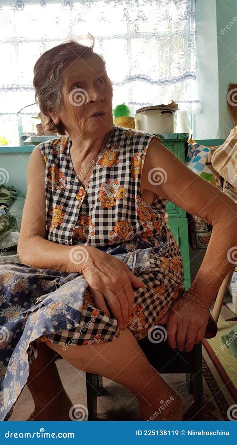 senior woman saying something and sitting with hand on her knees stock