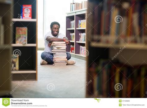 happy student  stacked books sitting  stock photo image