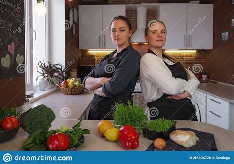 Young Girlfriends In The Kitchen Cooking A Vegetarian Meal Together