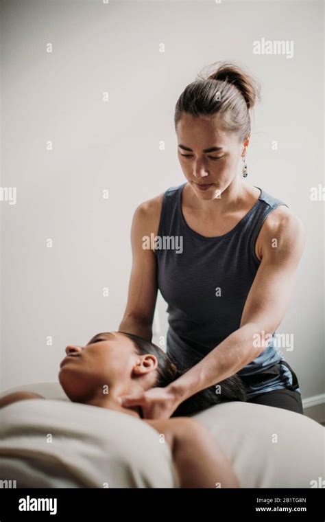 Female Massage Therapist Treats Her African American Patient Stock