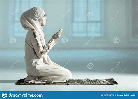 beautiful muslim woman in hijab dress sitting in mosque and praying