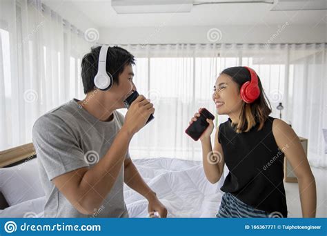 Asian Couple Lovers Listening To Music And Singing On His