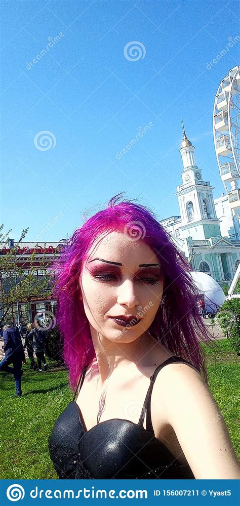 A Gothic Girl With Purple Hair In A Black Dress Stock