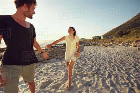 image  young couple enjoying    beach  sunset woman catching hand