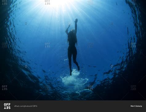 Underwater Silhouette Of Woman Swimming In The Ocean S Blue Water Stock