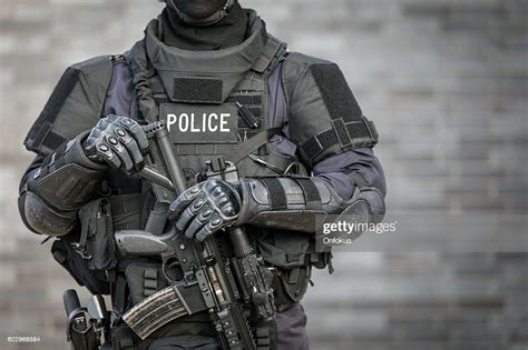 swat police officer against brick wall high res stock