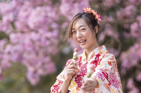 Japanese Woman In Traditional Kimono Dress Holding Sweet Hanami Dango