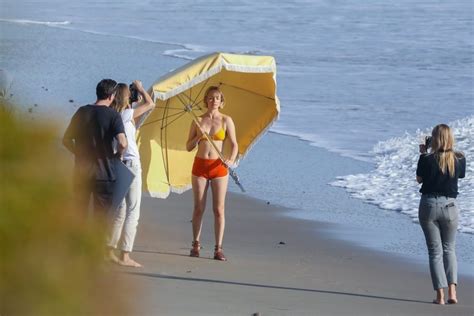 amber valletta poses in a bikini with a big umbrella on
