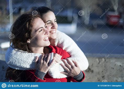 Side View Of Two Happy Women Embracing And Looking Away Lesbian Couple