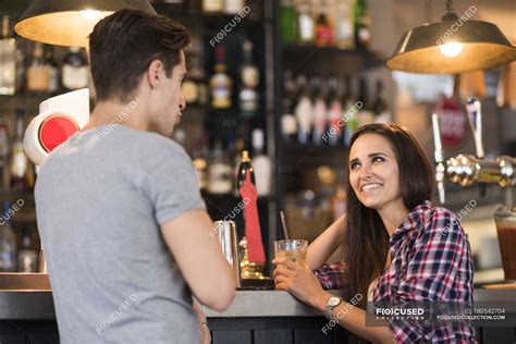 young couple talking  bar woman wearing stock photo