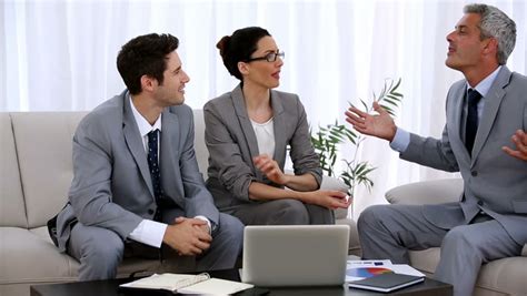 Two Business People Working While Sitting At A Desk In A