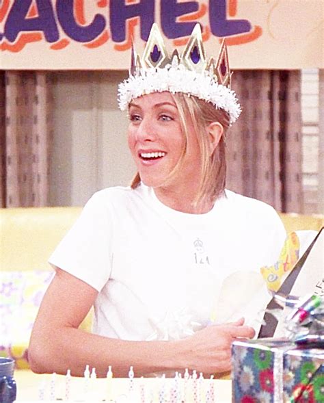 A Woman Wearing A Crown Sitting In Front Of A Cake On Top Of A Table