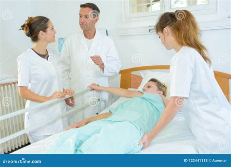 nurse rolling patient over in hospital bed stock image image of