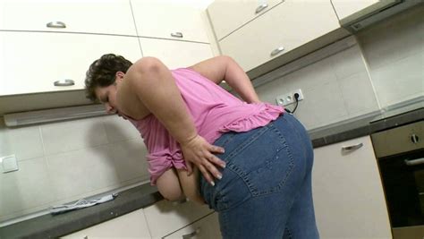 mature white bbw housewife in jeans and purple blouse in the kitchen