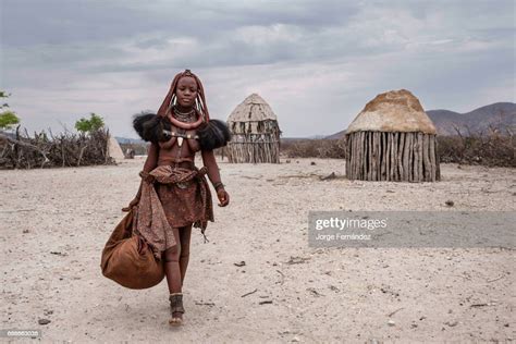 himba woman ready to travel with her belongings in a village near