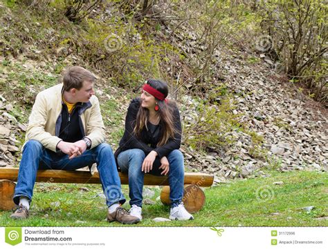 Couple Chatting Outdoors Sitting On Royalty Free Stock