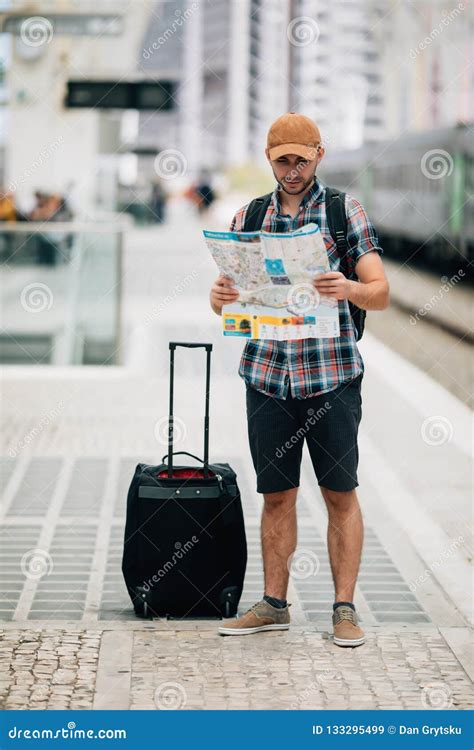 young man holding map standing  platform  train station  travel travel concept  train