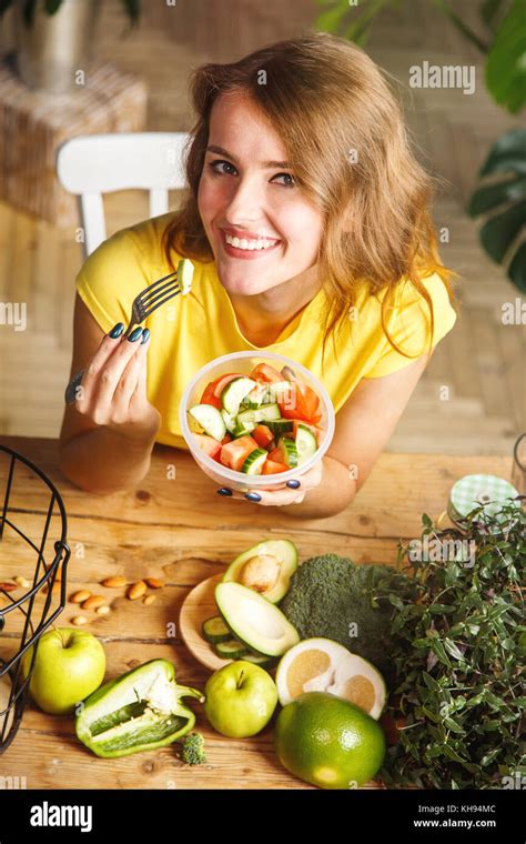 Attractive Slim Girl Eating Vegetable Salad At The Wooden Table Full