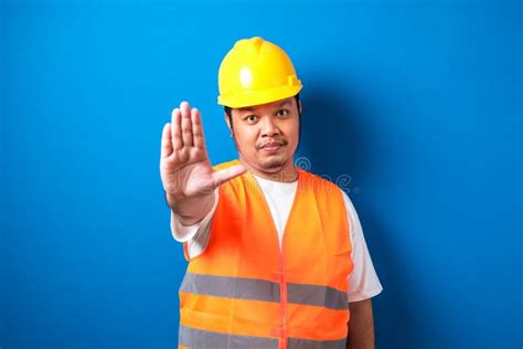 Fat Asian Workman Wearing Orange Safety Vest And Yellow Helmet Making