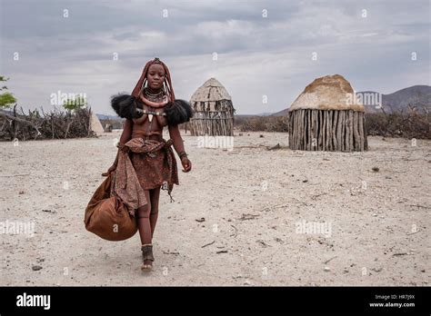 himba woman ready to travel with her belongings in a village near epupa