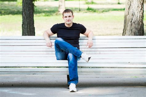 der junge mann sitzt auf einer bank stockfoto bild von gruen relax