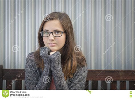 portrait of melancholy teen bookworm girl wearing glasses