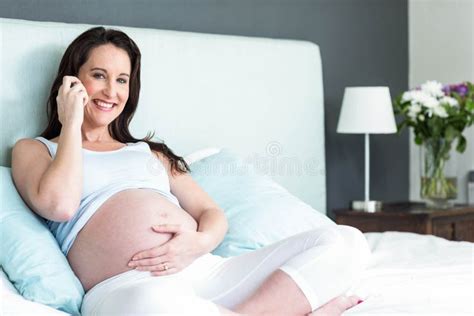 pregnant woman lying in bed making a phone call stock image image of