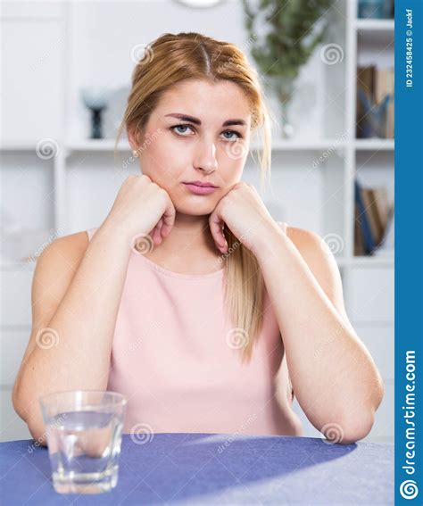 sad woman is sitting at the table alone and upset stock image image