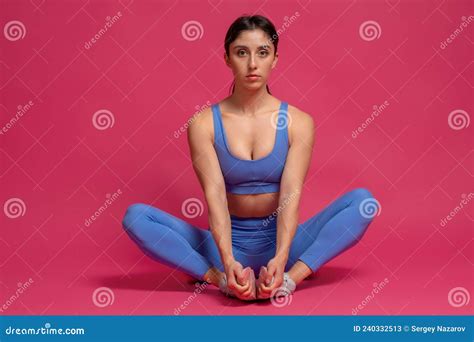 Sporty Brunette Performing Stretching Workout On Maroon Background