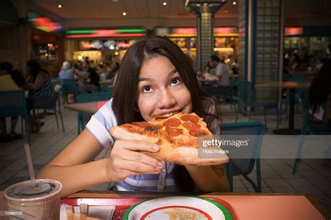teenage girl eating pizza in mall food court stock foto getty images