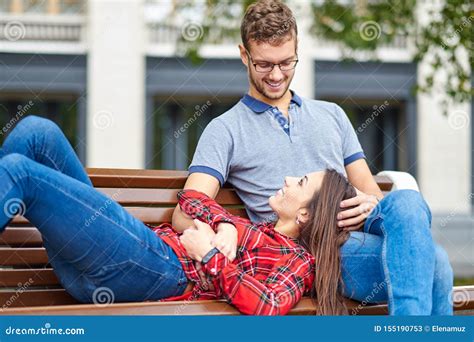 lovely portrait   young couple   sitting   bench embracing  kissing stock