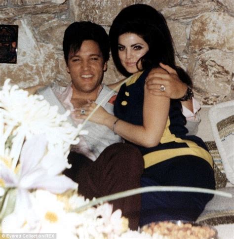 priscilla presley poses in front of gigantic elvis photo at convention