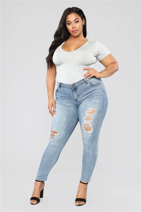 a woman in ripped jeans posing for the camera