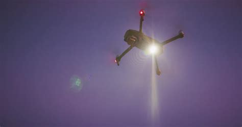 uav drone orbiting   sky shining  search spotlight  night drone technology