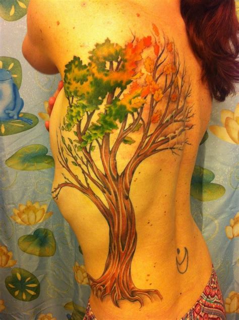 A Womans Back With A Tree Tattoo On Her Body And The Bottom Part Of