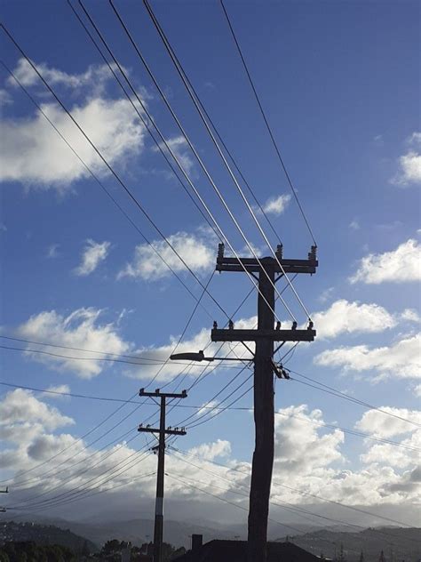 power lines  telephone poles   blue sky  white clouds    ground