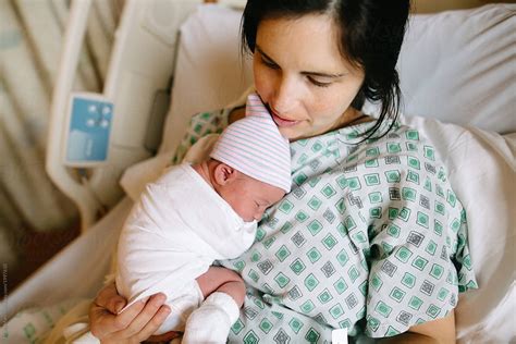 mother holds newborn baby  hospital bed  stocksy contributor